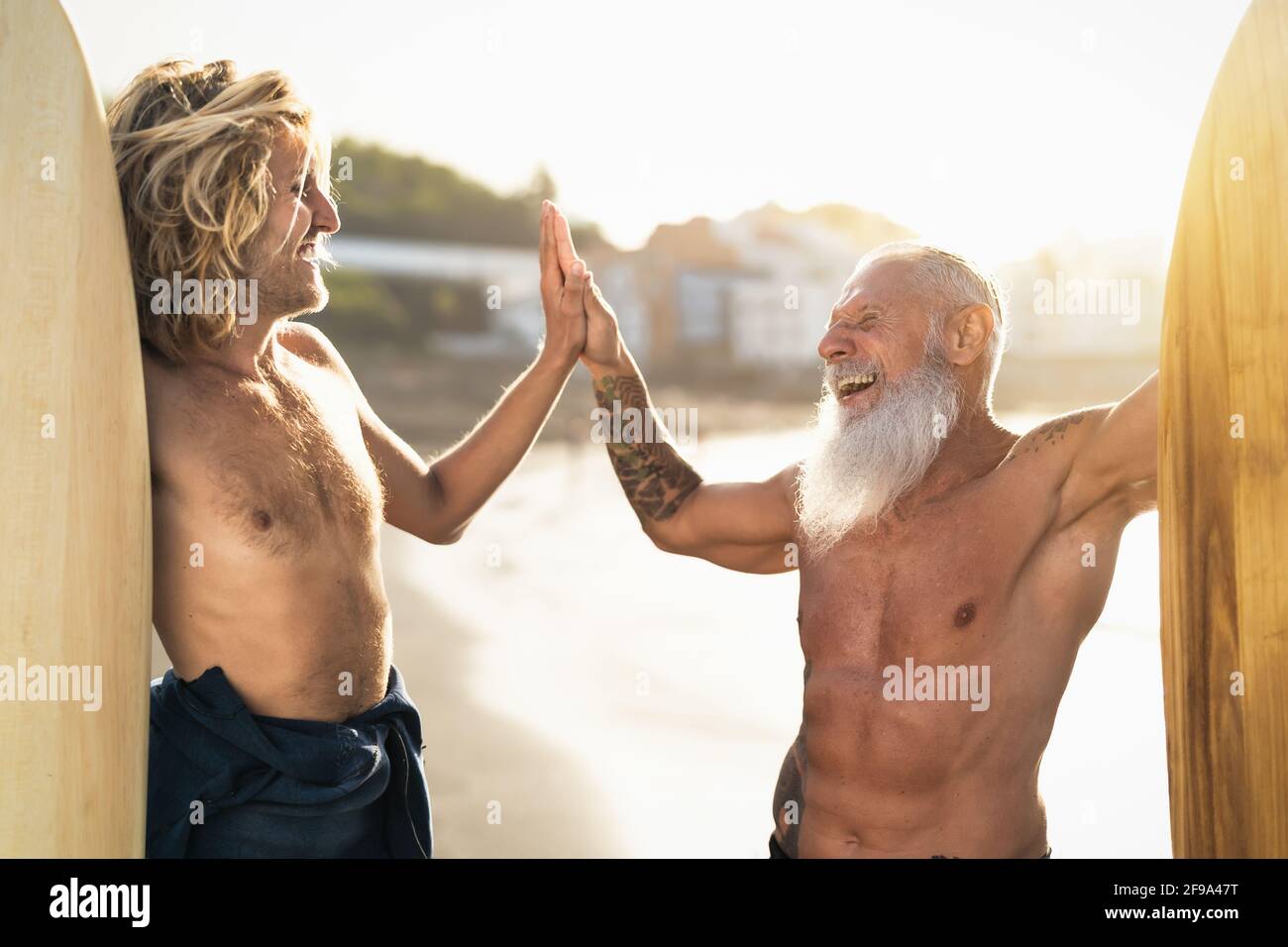 Amici felici con diverse età surf insieme - persone sportive Divertirsi durante la giornata di surf in vacanza - stile di vita sportivo estremo concetto Foto Stock