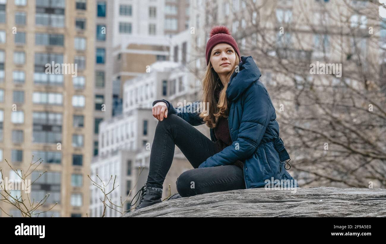 Giovane donna si rilassa su una roccia a Central Park New York - fotografia di viaggio Foto Stock