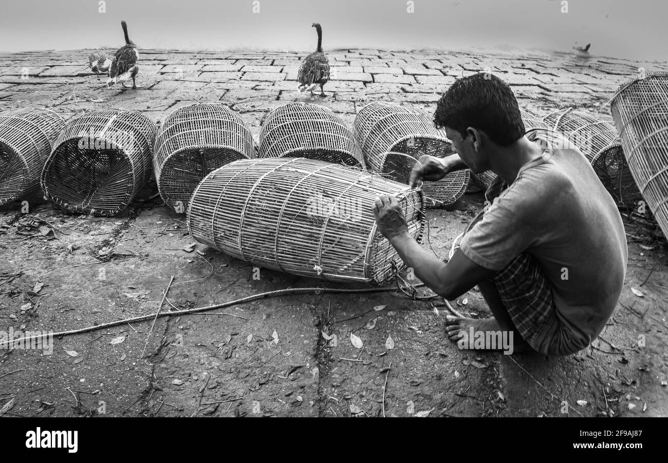 Pescatore in preparazione per la pesca con gabbia e corda sulla riva del fiume ho catturato questa immagine il 15 settembre 2020 da Chandpur, Bangladesh Foto Stock