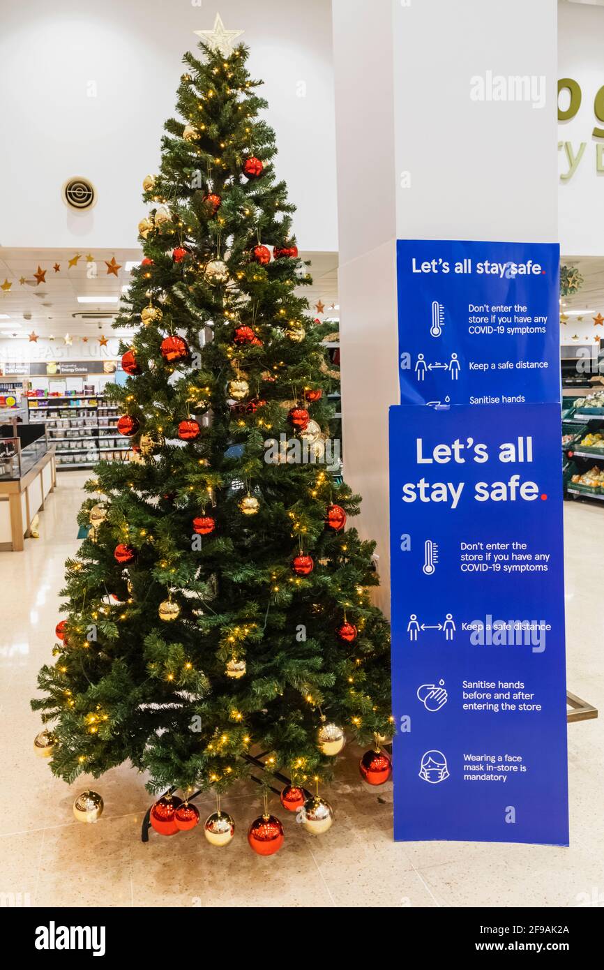 Inghilterra, Londra, Supermarket Christmas Tree e Social Distancing Sign Foto Stock