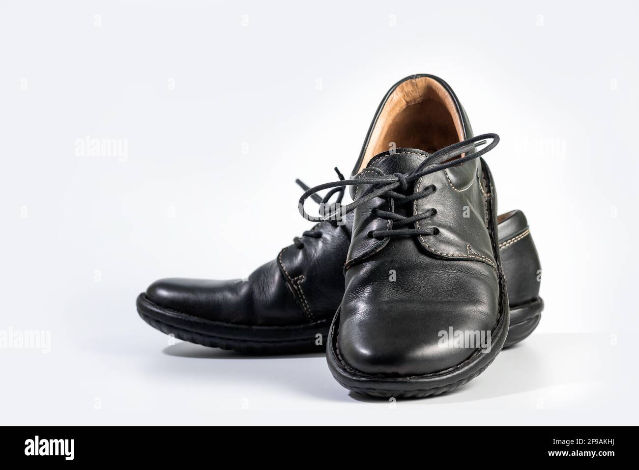 Scarpe in pelle nera da uomo. Primo piano di un paio di sneaker nere o scarpe  sportive con lacci isolati su sfondo bianco. Elegante e alla moda uomo  piedi Foto stock -