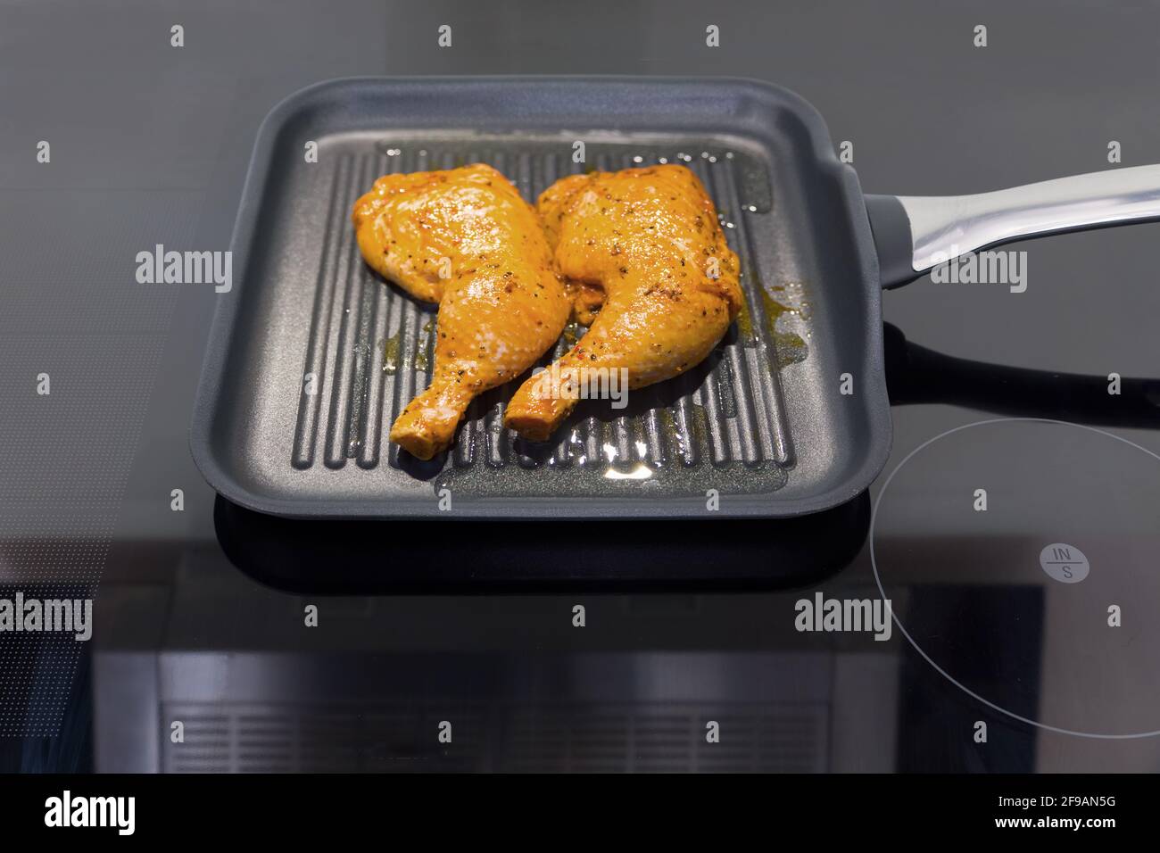 Due cosce di pollo in una padella Foto Stock
