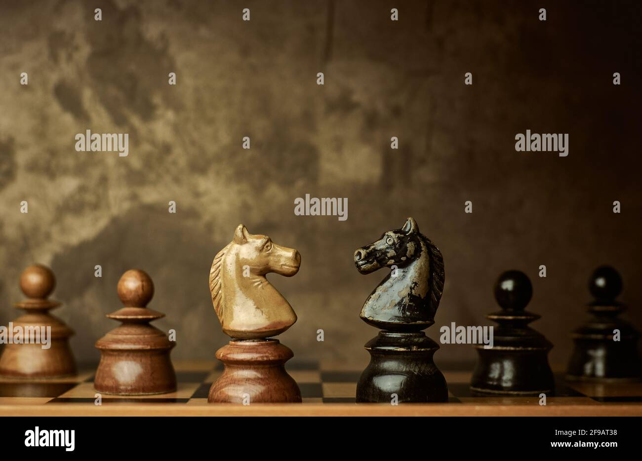 Duello di cavalieri di legno pezzi di scacchi l'uno di fronte all'altro Foto Stock