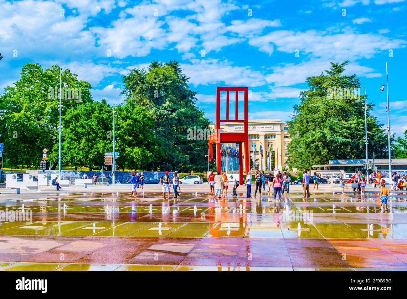 GINEVRA, SVIZZERA, 20 LUGLIO 2017: I turisti ammirano la scultura di una sedia rotta di Daniel Berste di fronte al Palazzo delle Nazioni di Ginevra, Foto Stock