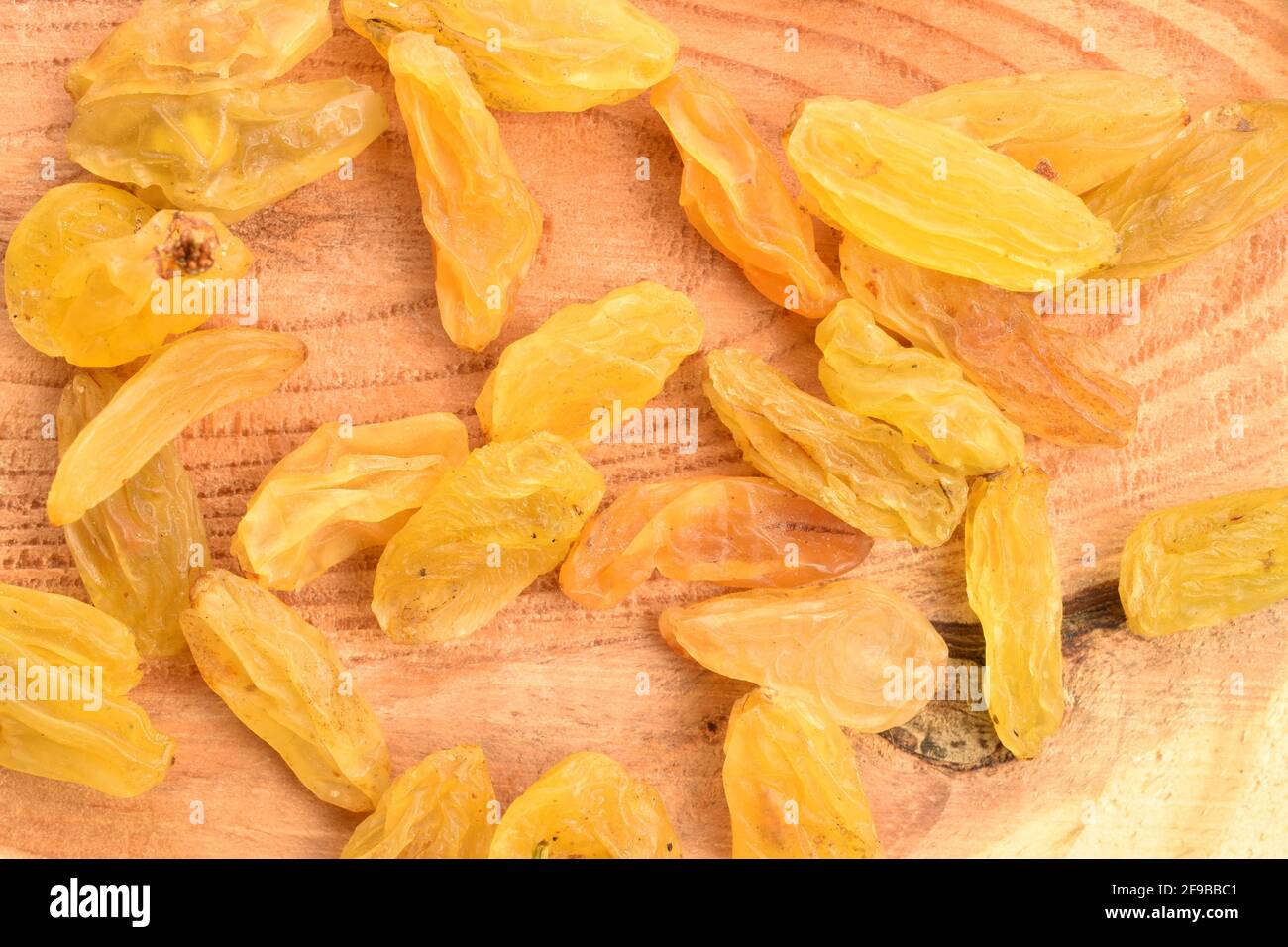 Diversi bacche di uva passa dorata, dolce, organica, naturale, secca, macro, tavolo in legno. Foto Stock