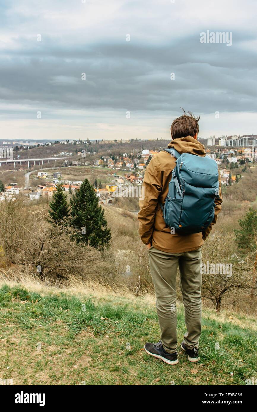 Uomo con zaino che gode di vista della riserva naturale della valle di Prokopske E quartiere residenziale, Praga, Repubblica Ceca.attraente paesaggio Foto Stock