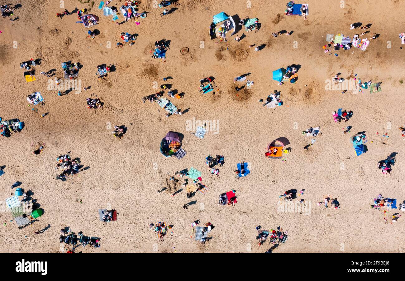 Aberdour, Scozia, Regno Unito. 17 aprile 2021. Sole ininterrotto e temperature calde di 14C hanno portato folle di famiglie alla popolare Silversands Beach ad Aberdour, Fife. Il pubblico stava sfruttando appieno le restrizioni di viaggio in Scozia che sono entrate in vigore venerdì. Un parcheggio per auto è stato allestito in un parco per far fronte alle centinaia di auto che scesero sulla spiaggia. Iain Masterton/Alamy Live News Foto Stock