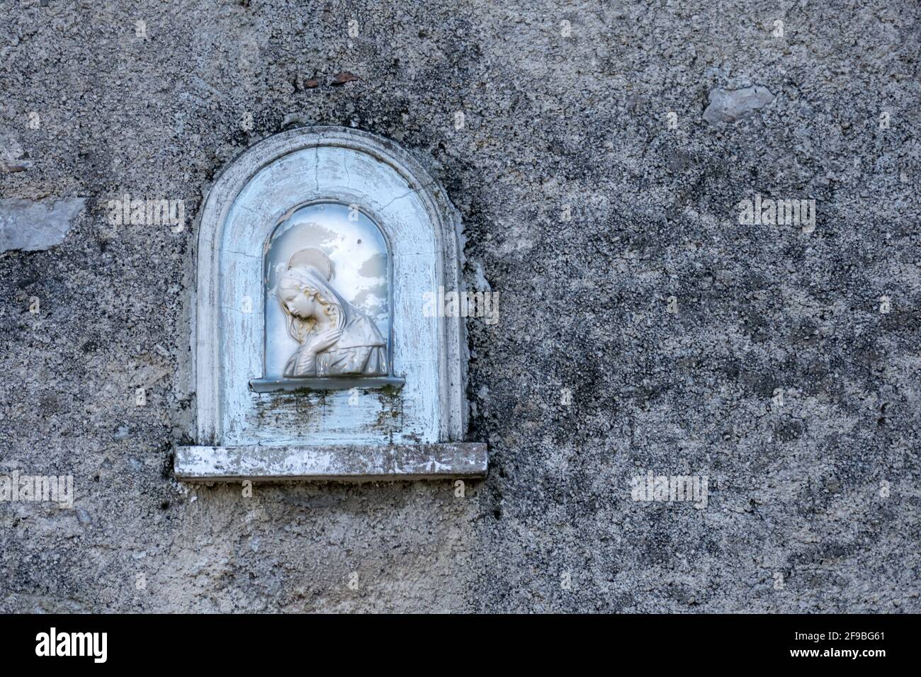 Primo piano della scultura della Vergine Maria montata su una parete a Pisa, Toscana, Italia Foto Stock
