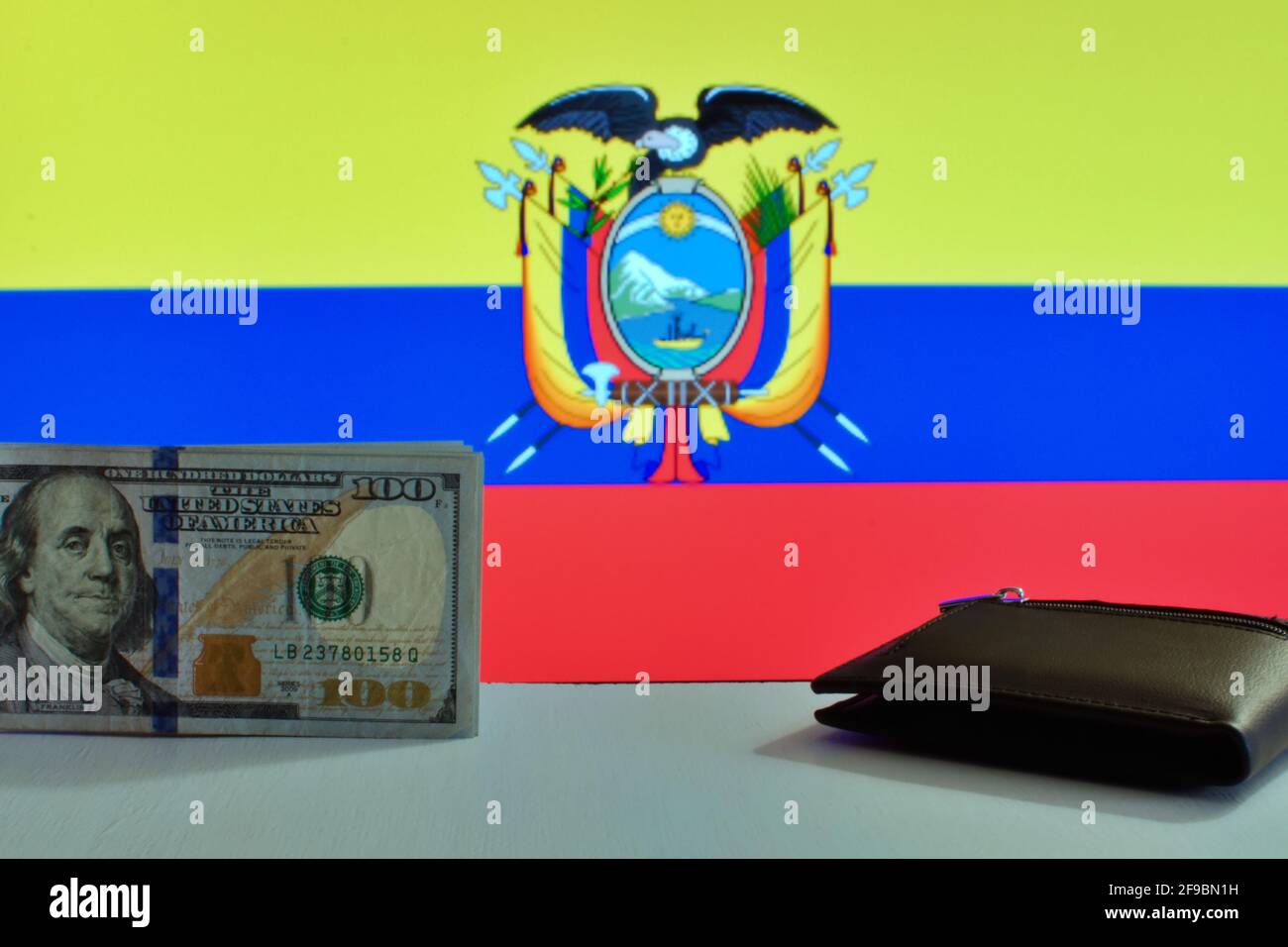 Banconota e portafoglio da 100 dollari USA su sfondo sfocato di Bandiera nazionale dell'Ecuador Foto Stock