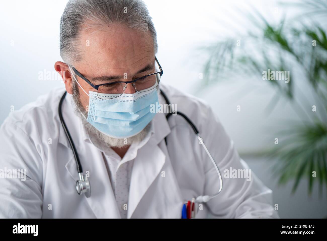 Ritratto di dottore in mano bianca e phonendoscope di lavoro nel suo ufficio Foto Stock