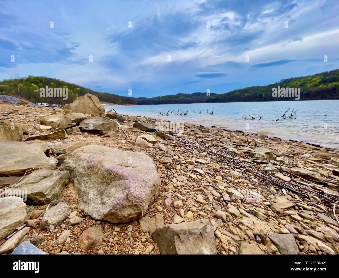 Tygart Lake nel Tygart Lake state Park nella Virginia occidentale, in primavera con la costa piena di sabbia e rocce che conducono alle acque ondulate con il Foto Stock