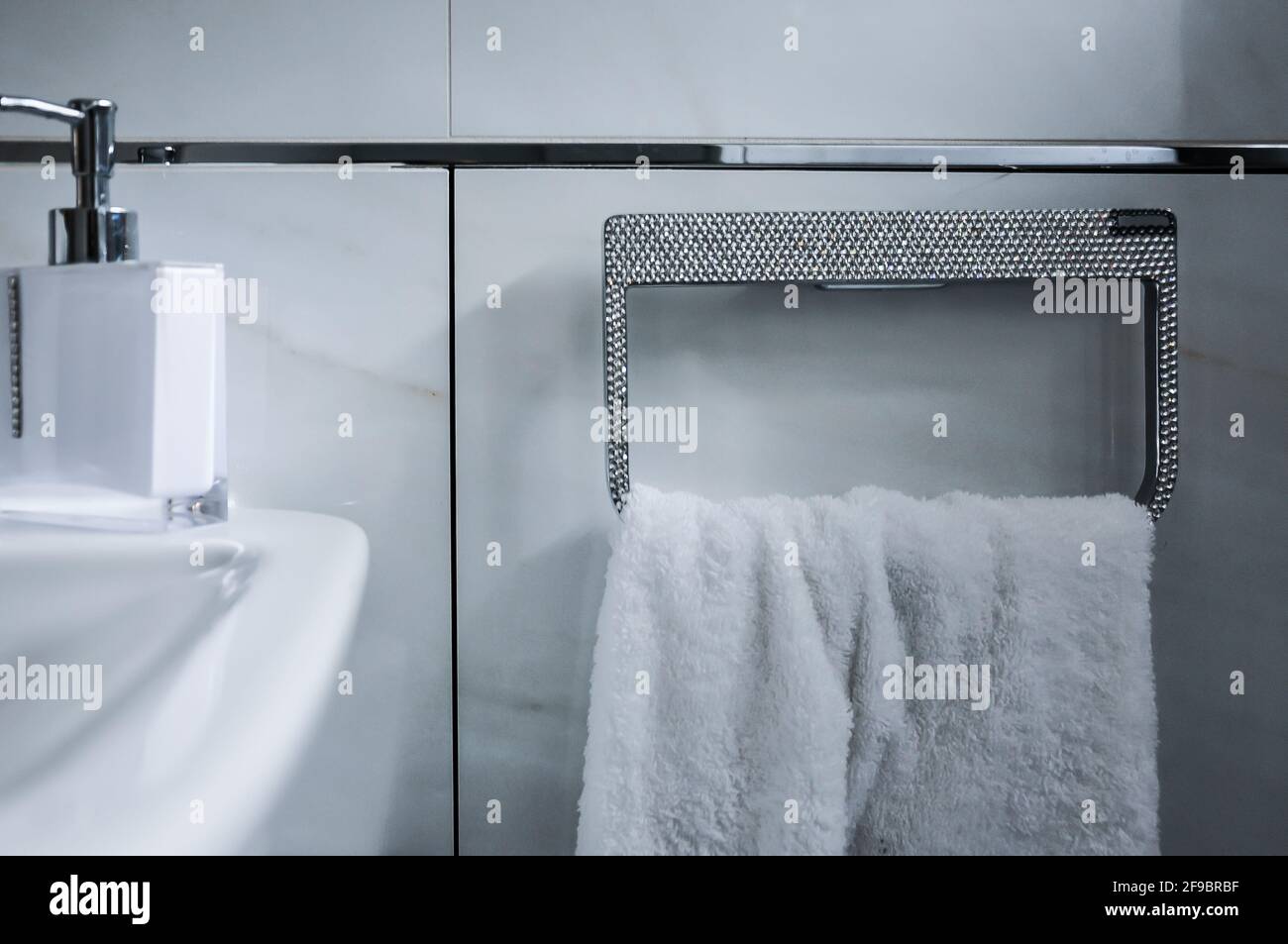 Dettaglio di un bagno. Portasciugamani con strass, anello portasciugamani con asciugamano bianco Foto Stock