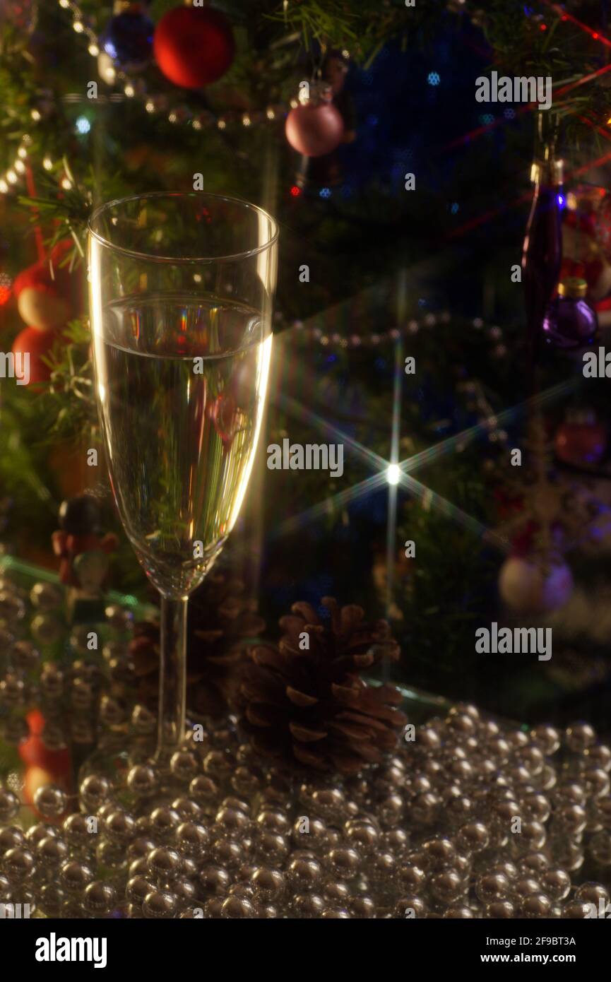 Un bicchiere di vino sullo sfondo di alberi di Natale e decorazioni natalizie. Umori di Natale. Foto Stock