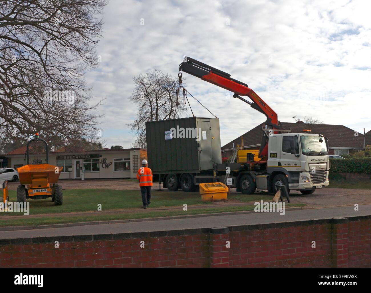 Un'unità mobile temporanea che viene scaricata da un veicolo di trasporto vicino ad un sito di lavori a Hellesdon, Norfolk, Inghilterra, Regno Unito. Foto Stock