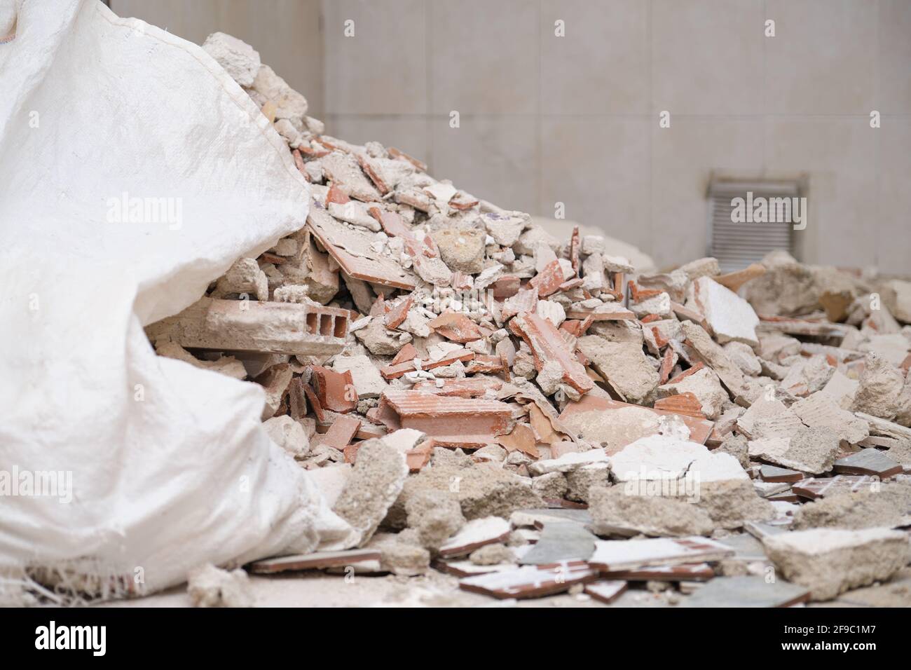 Contenere i detriti in un cantiere. Calcestruzzo e detriti di mattoni. Foto Stock