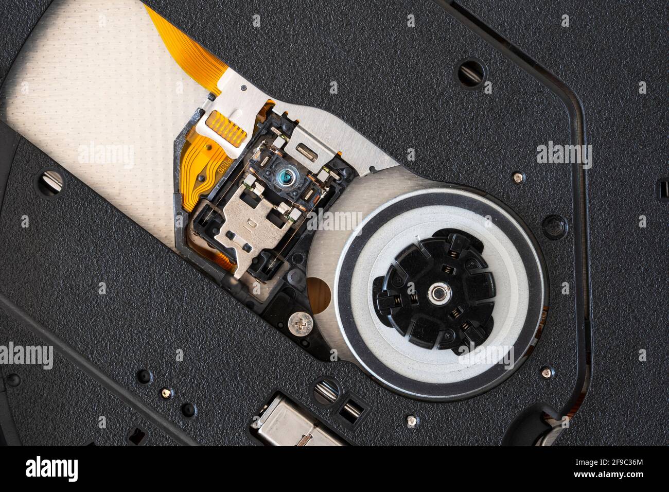 Una macro su un'unità disco ottica CD DVD-ROM di tipo sottile esterna che mostra la testina di prelievo (PUH), l'obiettivo e il vassoio Foto Stock