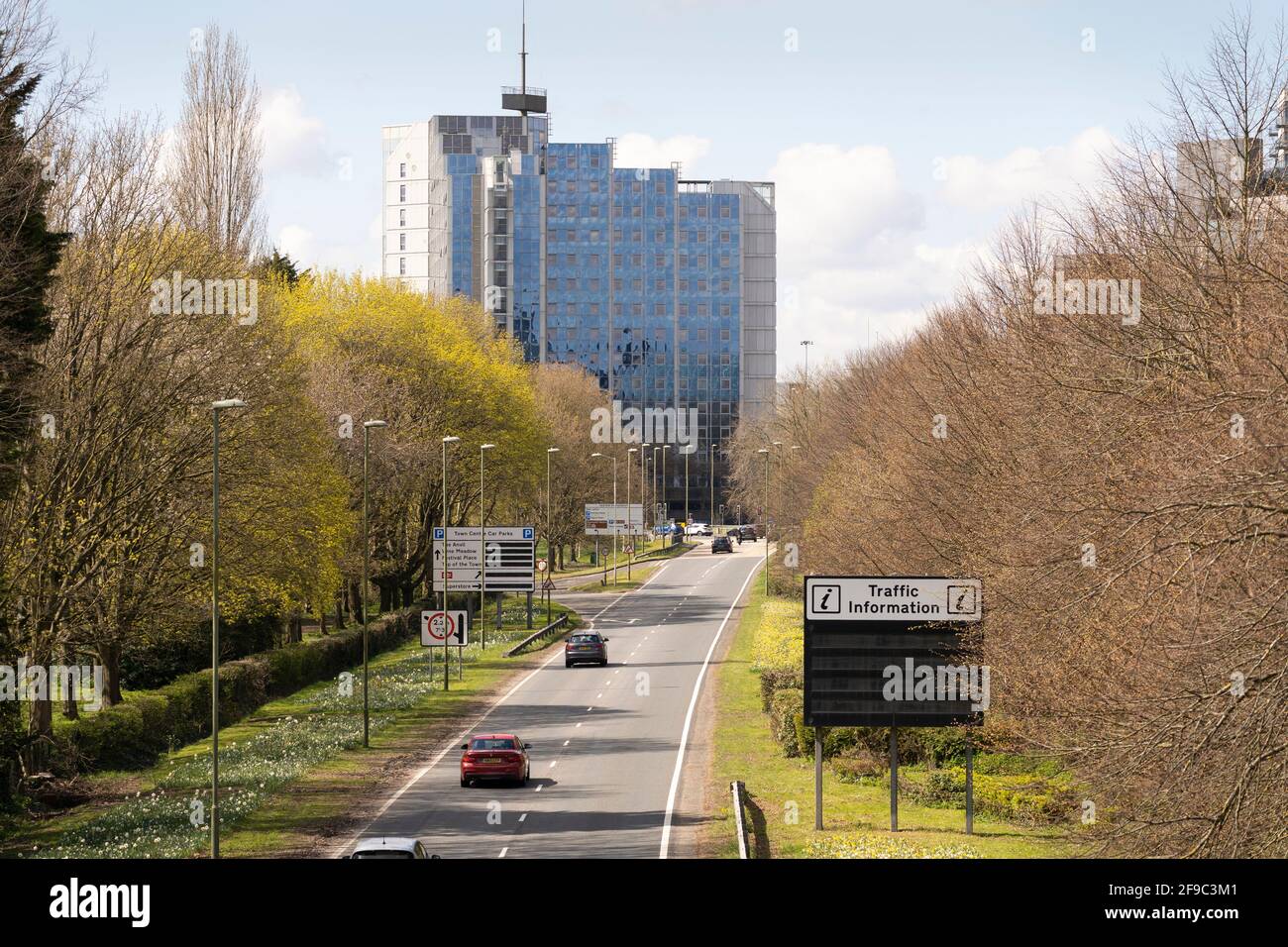 Le auto si avvicinano al centro di Basingstoke lungo Churchill Way East in una giornata primaverile con gli alti appartamenti Churchill Place sullo sfondo. REGNO UNITO Foto Stock