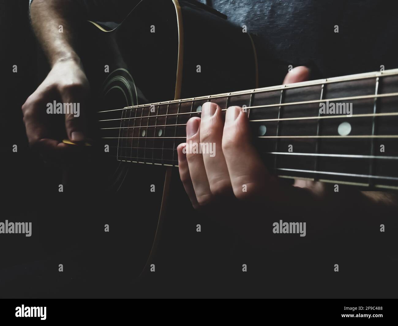 mani dell'uomo che suonano closeup di chitarra acustica Foto Stock