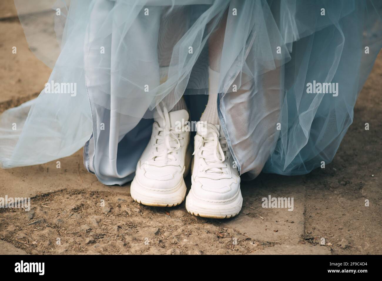 sneaker bianche e abito da palla blu Foto Stock