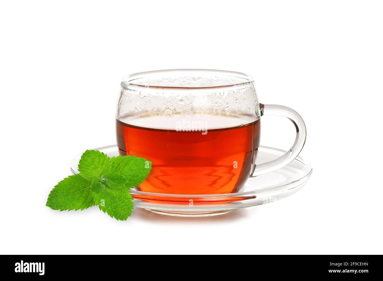Studio di una tazza di tè di vetro con menta foglia isolata su sfondo bianco in primo piano Foto Stock