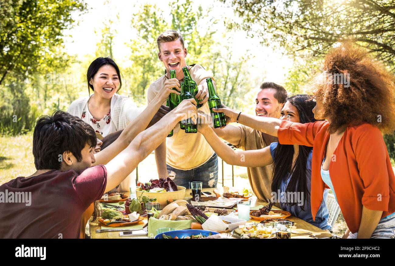 Giovani amici multirazziali che tostano al barbecue Garden party - amicizia concetto con la gente felice che si diverte a cortile bbq estate campo Foto Stock