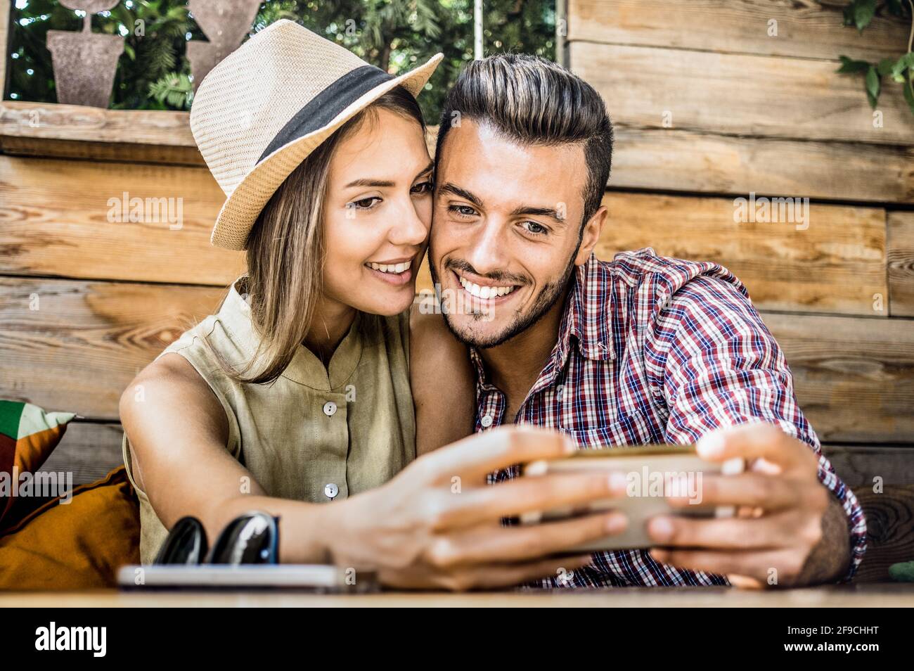 Giovane coppia amante della moda all'inizio della storia d'amore - Bell'uomo che prende selfie con bella donna al caffè di moda Bar - concetto di relazione Foto Stock