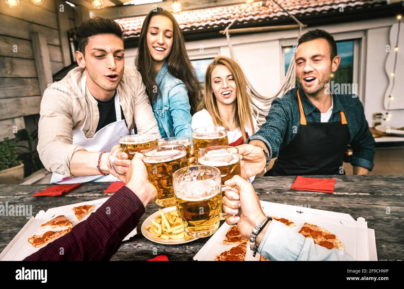 Punto di vista dei giovani amici che mangiano pizza da asporto A casa patio dopo il lavoro - concetto di amicizia con felice persone che si divertono insieme Foto Stock