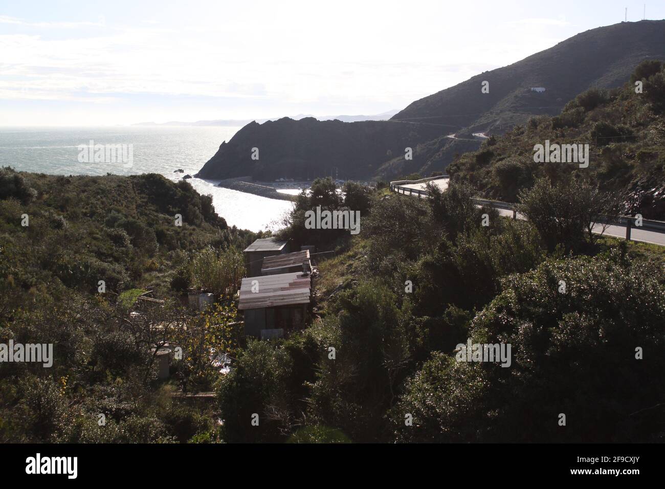 Capanne in ferro corrugato in una valle con vista sull'oceano Foto Stock