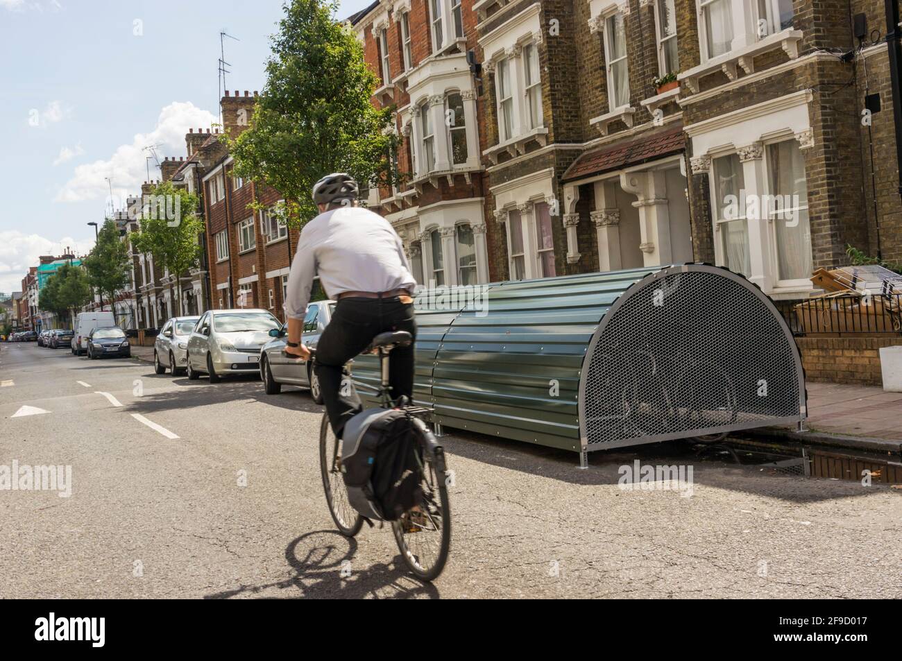 Ciclista (movimento sfocato) passaggio di deposito bici su strada bloccabile. Foto Stock