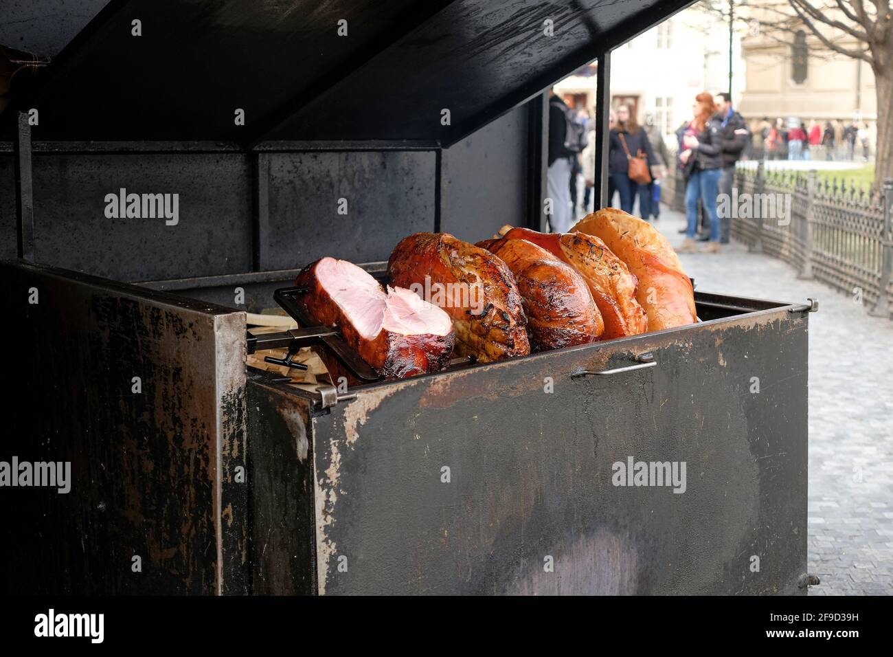 Prosciutto arrosto nel centro di Praga, preparazione di cibo di strada Foto Stock