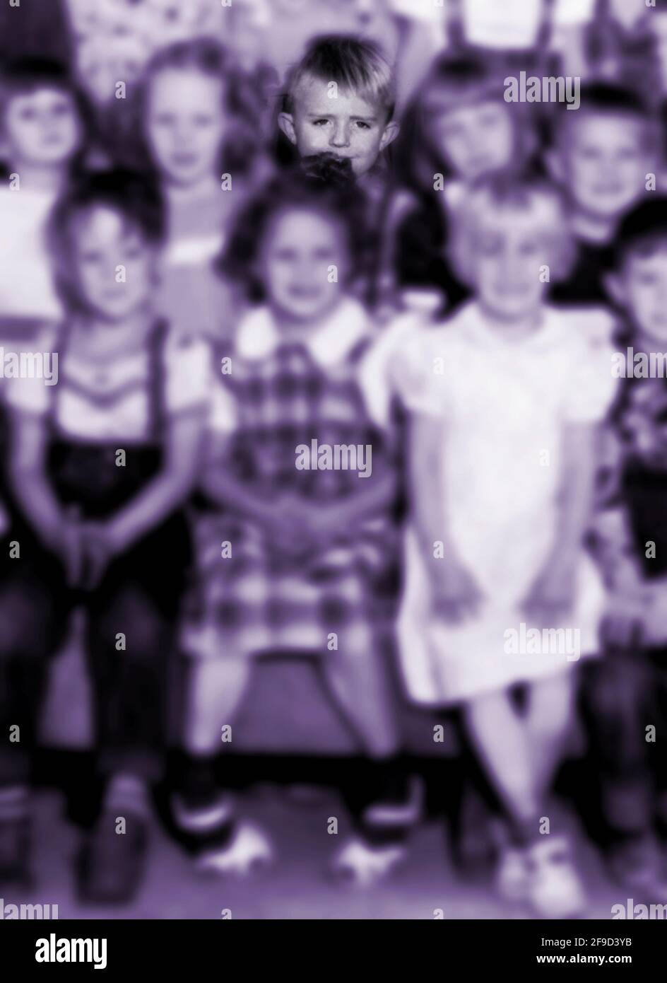 Una fotografia d'epoca di una classe d'asilo californiana scattata nel 1951 colorò e alterò digitalmente per enfatizzare un ragazzo nel ritratto di gruppo. Foto Stock