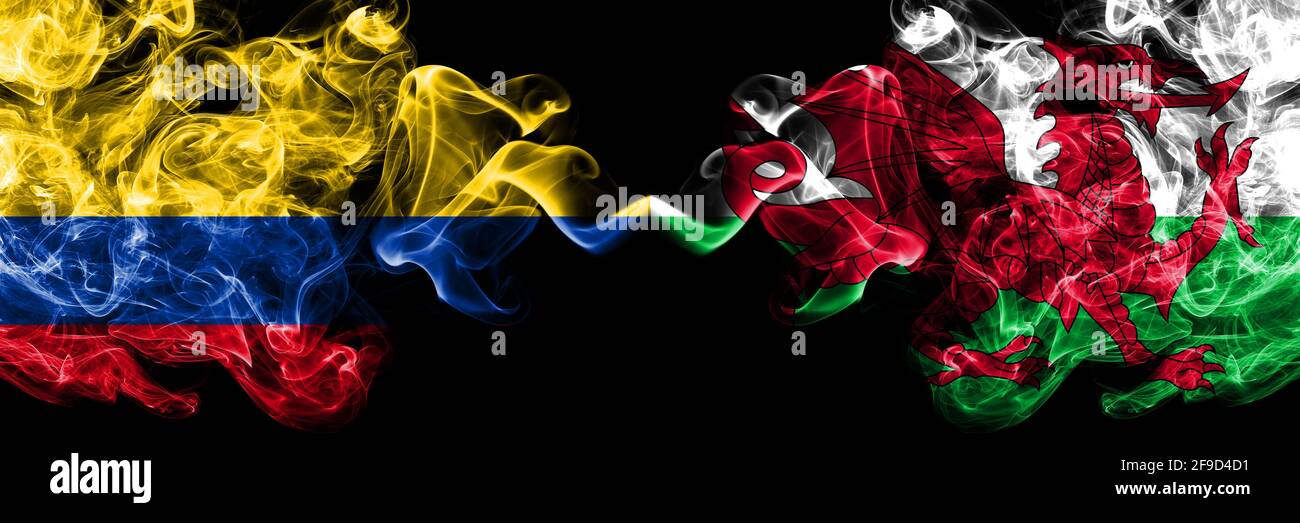 Colombia, Colombia vs Galles, Regno Unito bandiere mistiche fumose affiancate. Bandiere di fumo astratte spesse colorate in seta. Foto Stock