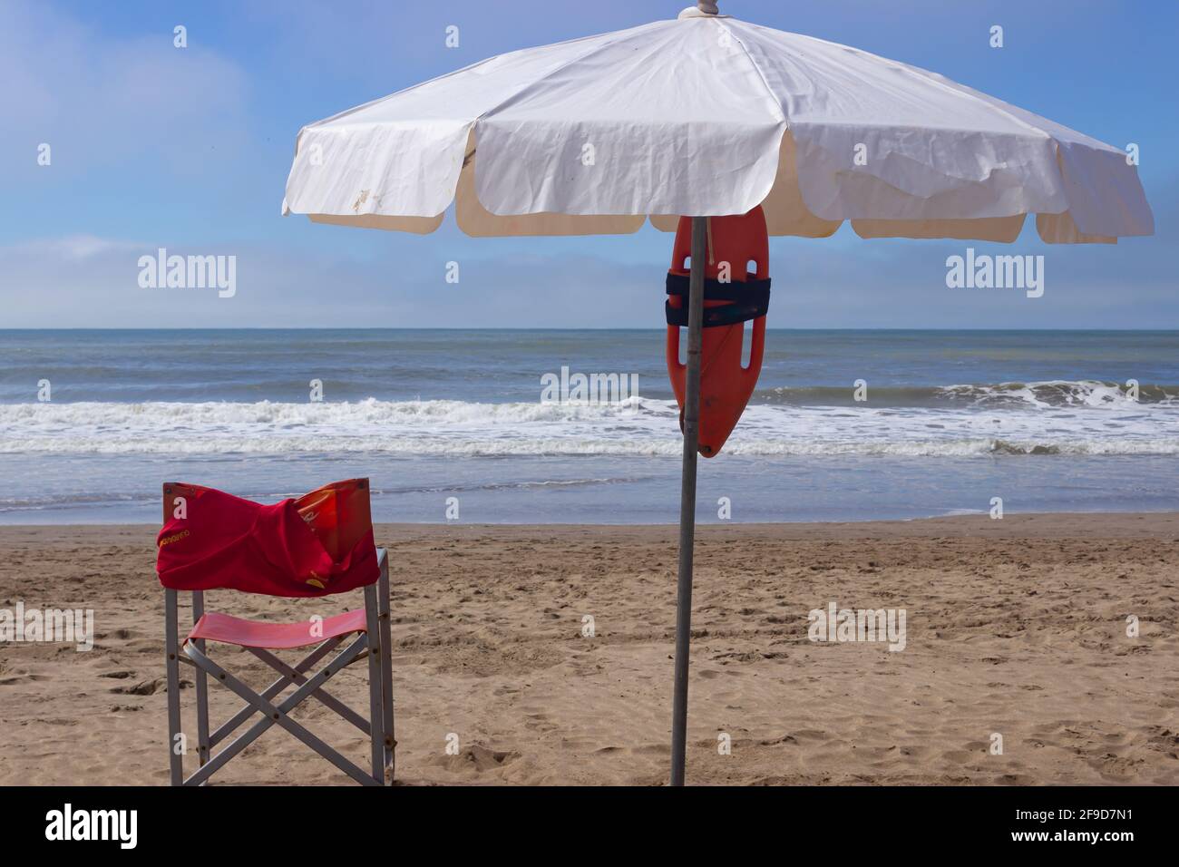Ombrellone e bagnini in spiaggia in una giornata di sole. Foto Stock