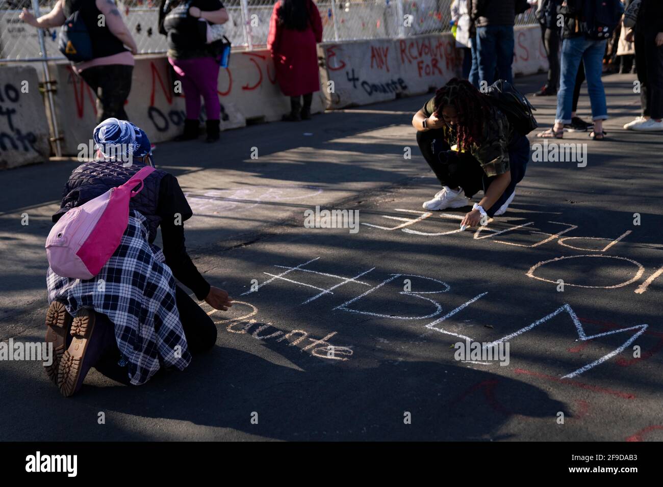 Brooklyn Center, Minnesota, Stati Uniti. 16 Apr 2021. Le persone scrivono in gesso come manifestanti riuniti fuori dal Brooklyn Center Police Department il 16 aprile 2021. Questo è stato il sesto giorno consecutivo di dimostrazioni dopo l'uccisione di Daunte Wright, 20 anni, da parte dell'ex ufficiale Kim Potter. Credit: Dominick Sokotoff/ZUMA Wire/Alamy Live News Foto Stock