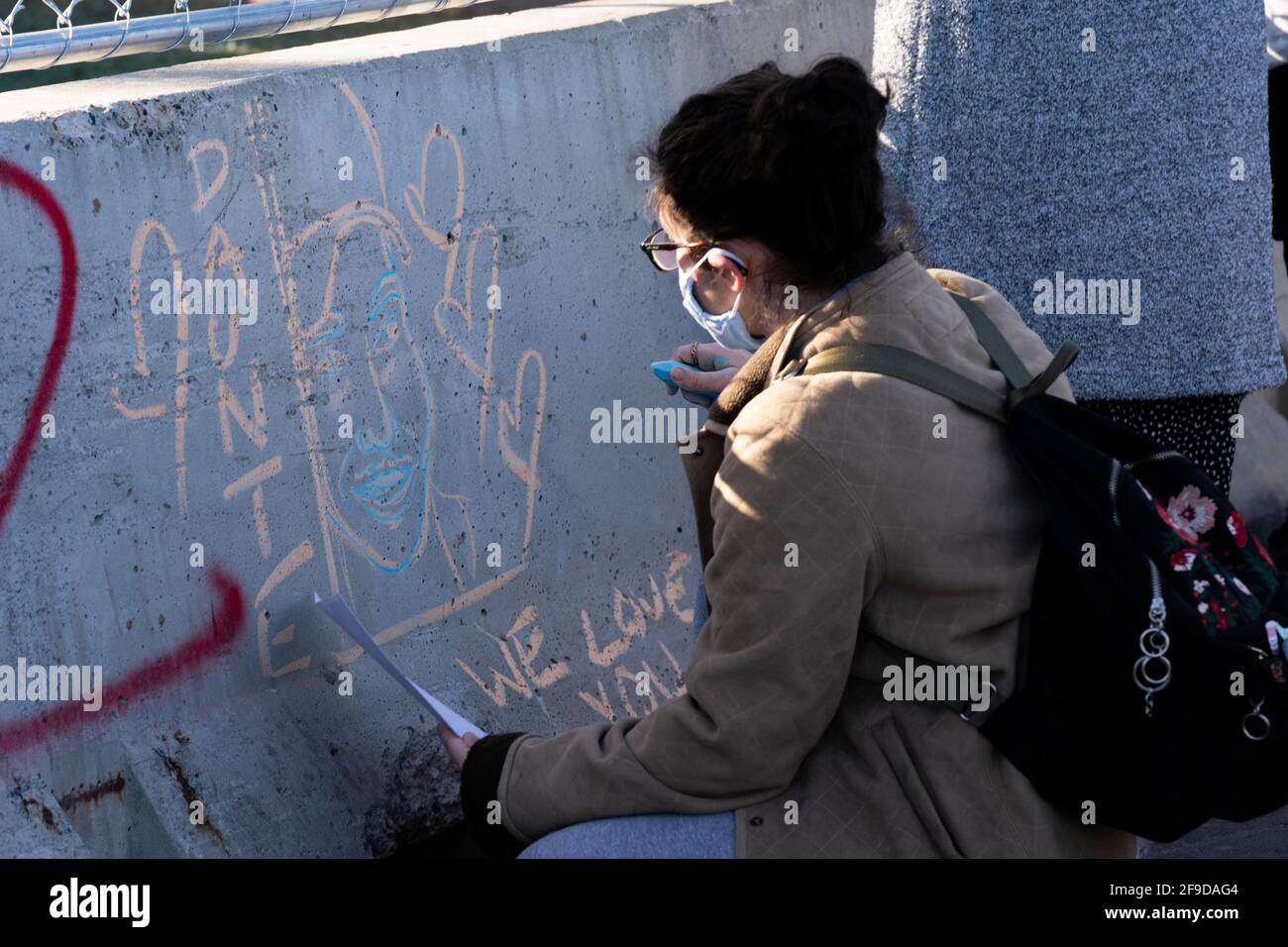 Brooklyn Center, Minnesota, Stati Uniti. 16 Apr 2021. Una persona disegna un ritratto di Daunte Wright su una barricata con gesso come manifestanti riuniti fuori del Brooklyn Center Police Department il 16 aprile 2021. Questo è stato il sesto giorno consecutivo di dimostrazioni dopo l'uccisione di Daunte Wright, 20 anni, da parte dell'ex ufficiale Kim Potter. Credit: Dominick Sokotoff/ZUMA Wire/Alamy Live News Foto Stock