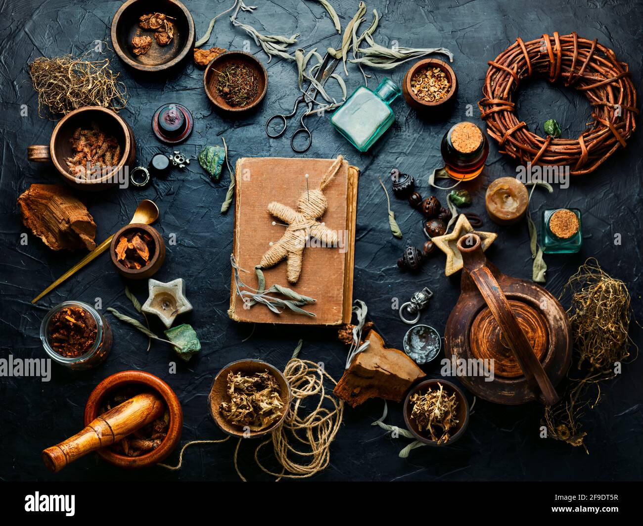 Bambola Voodoo, erbe magiche e attributi stregoneria su un vecchio tavolo Foto Stock