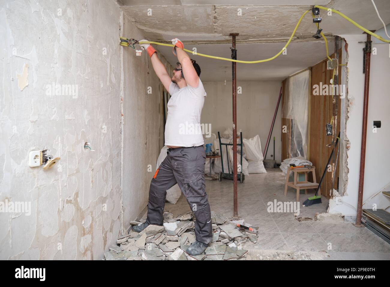 Elettricista riparatore che lavora in un cantiere. Sicurezza sul lavoro. Foto Stock