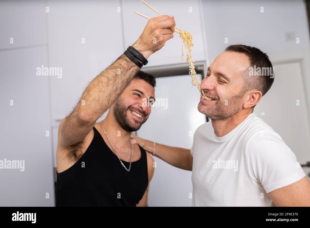 Uomo che alimenta la pasta al suo ragazzo in modo divertente Foto Stock