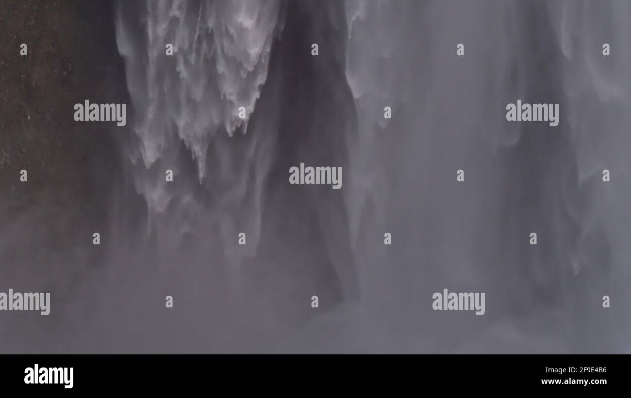 Vista in primo piano della famosa cascata di Skógafoss nel sud dell'Islanda con spray che assomiglia a una tenda d'acqua nella stagione invernale. Foto Stock