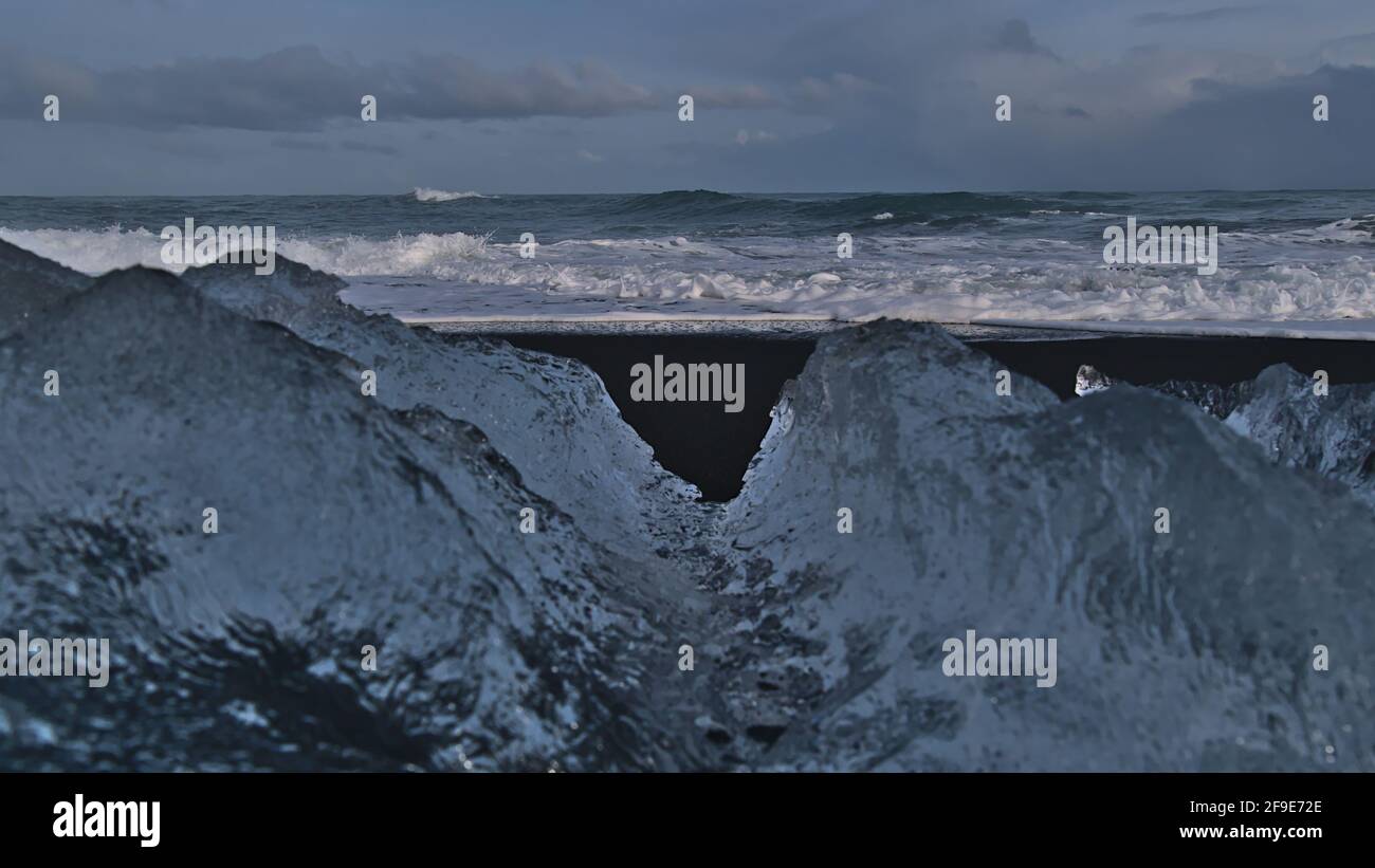 Splendida vista della famosa spiaggia di diamanti con sabbia nera e forte surf vicino alla laguna glaciale di Jökulsárlón e Route 1 nel sud dell'Islanda con iceberg. Foto Stock