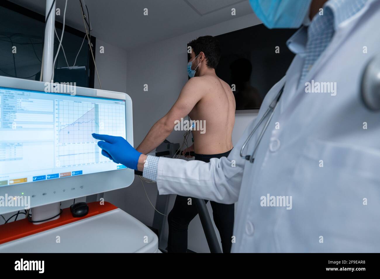 Dati di analisi della medica di ritaglio sul monitor digitale durante lo stress cardiaco test di paziente maschile che cammina sul tapis roulant Foto Stock