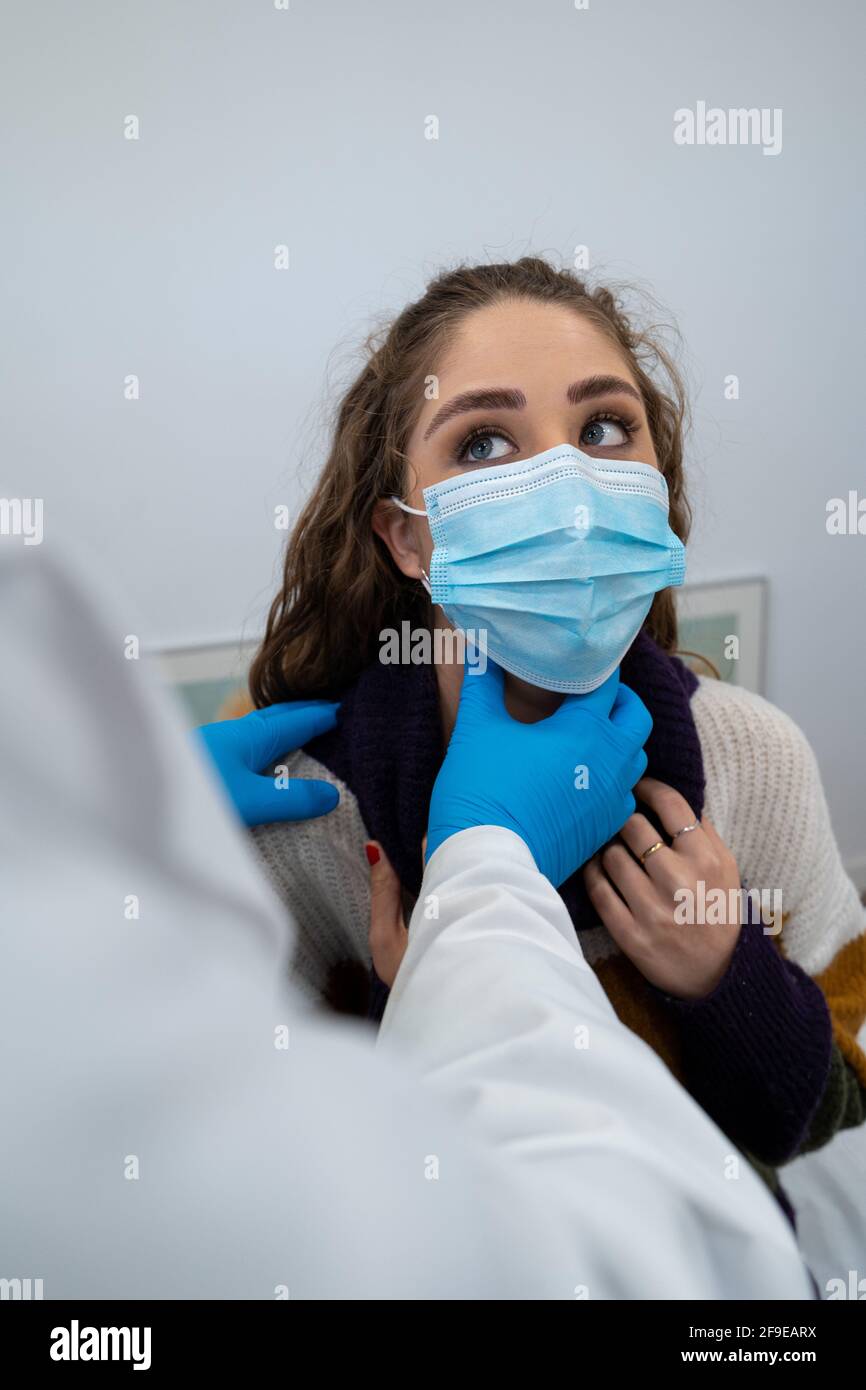 Medic irriconoscibile nei guanti che esaminano i linfonodi della paziente femminile durante l'appuntamento in ospedale moderno Foto Stock