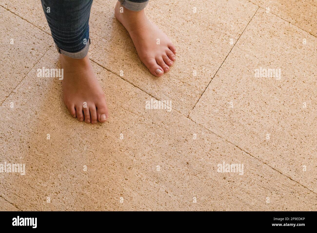 Dall'alto di raccolto irriconoscibile persona in jeans in piedi pavimento asciutto in casa Foto Stock
