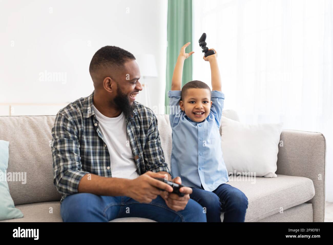 Ha entusiasmato l'African Boy e il suo videogioco vincitore del papà a casa Foto Stock