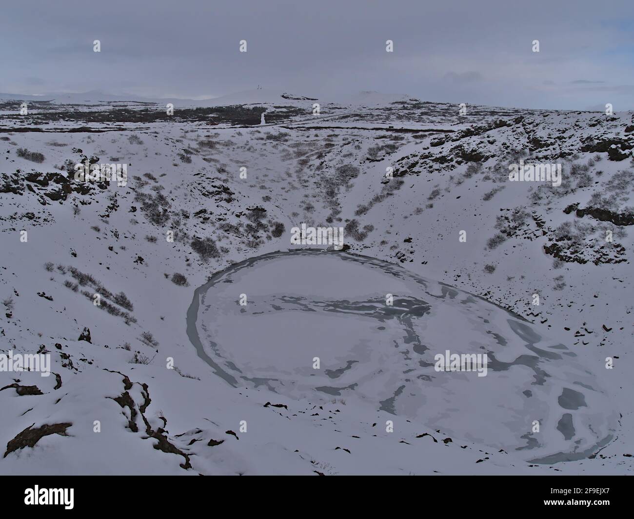 Vista del lago vulcanico congelato Kerið (anche Kerid, Kerith) a Grímsnes, Islanda, parte del cerchio d'Oro, con piste innevate in inverno. Foto Stock
