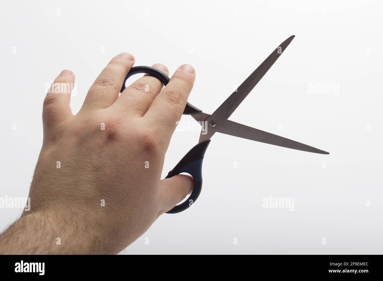 La mano tiene una forbice isolata su uno sfondo bianco. Forbici da  cancelleria a mano isolate su sfondo bianco Foto stock - Alamy
