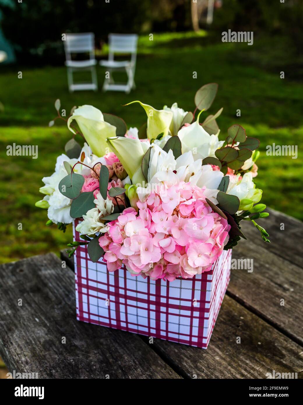 Fiori in confezione regalo all'esterno su tavolo di legno con testo spazio Foto Stock