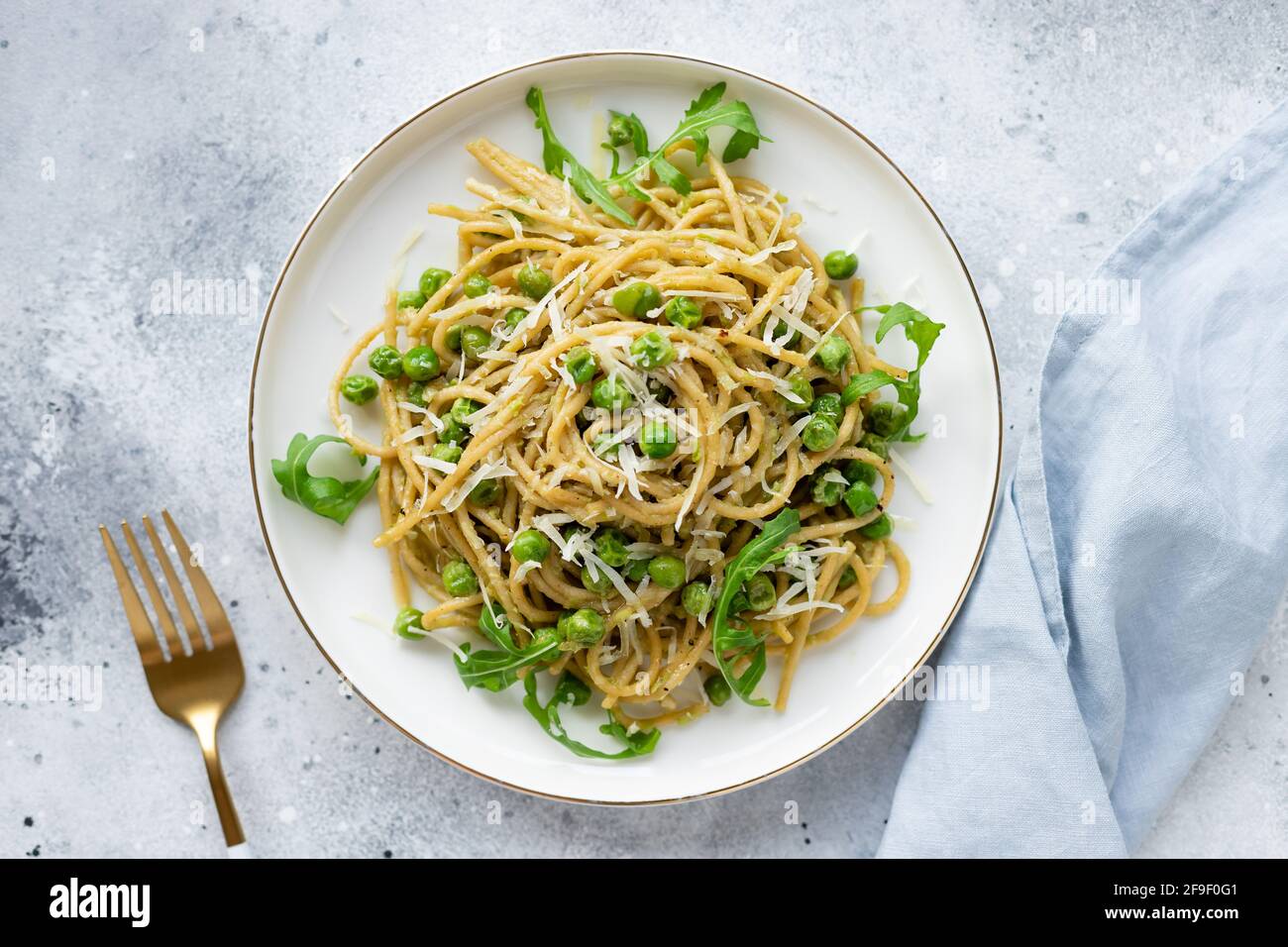 Piatto da pranzo vegano. Spaghetti di pasta con piselli verdi Foto Stock