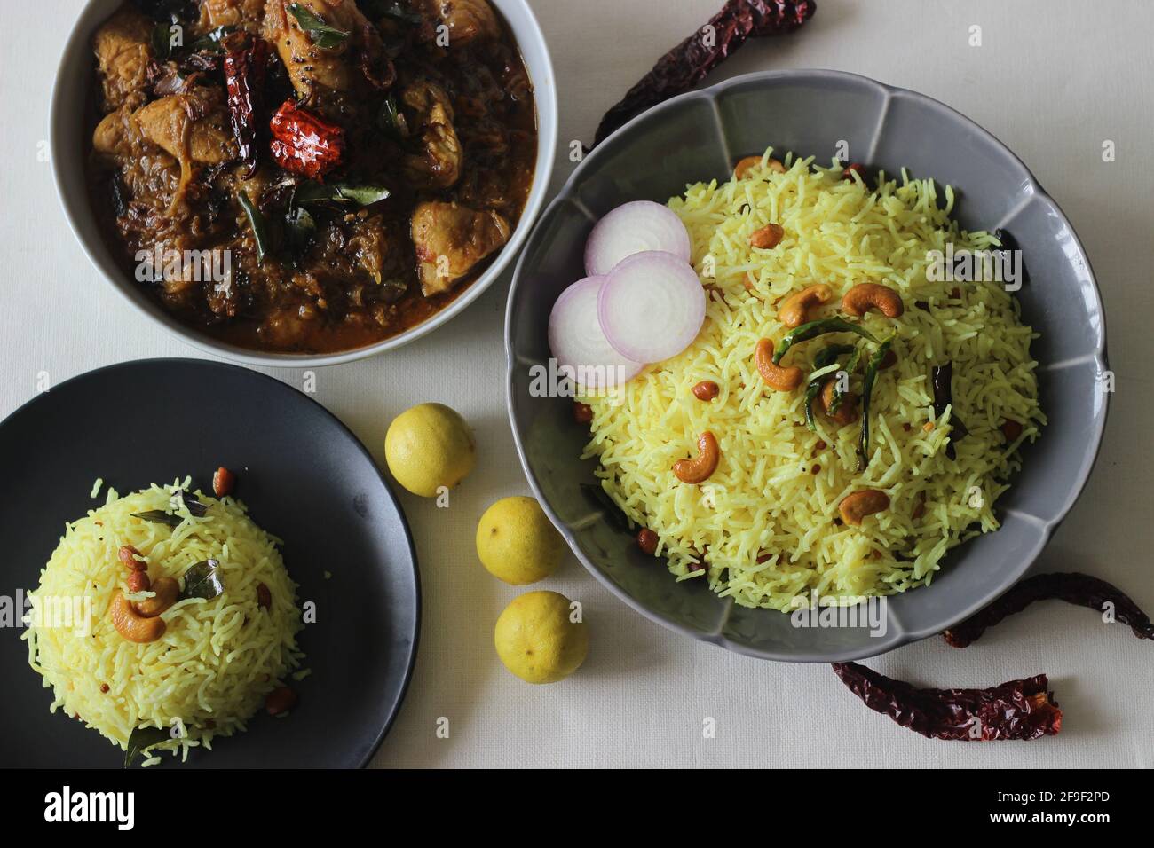 Riso al limone servito con curry di pollo in stile Kerala. Scatto su sfondo bianco. Foto Stock