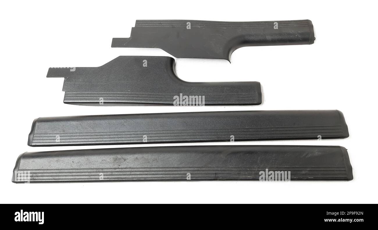 Un quattro di plastica nera decorativa porta batte in un analisi di automobili per la vendita o la riparazione in un'officina su uno sfondo bianco isolato in un fototundo Foto Stock